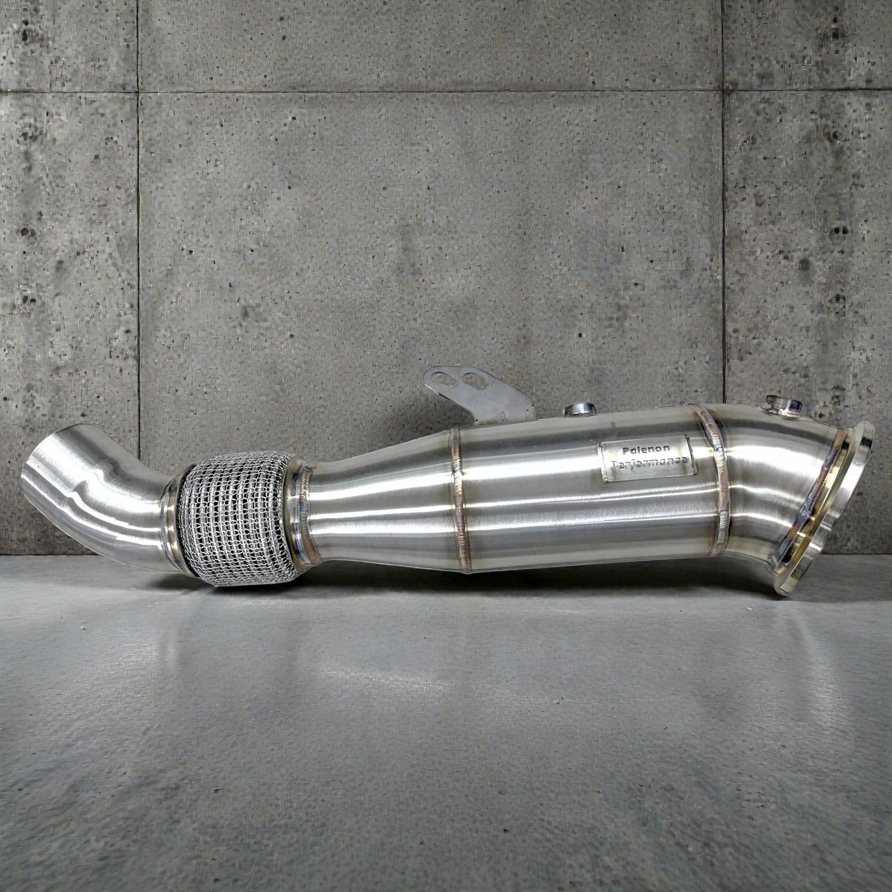 Palenon Performance 4.5-inch stainless steel racing downpipe for BMW B58 engines with a flexible mesh section.