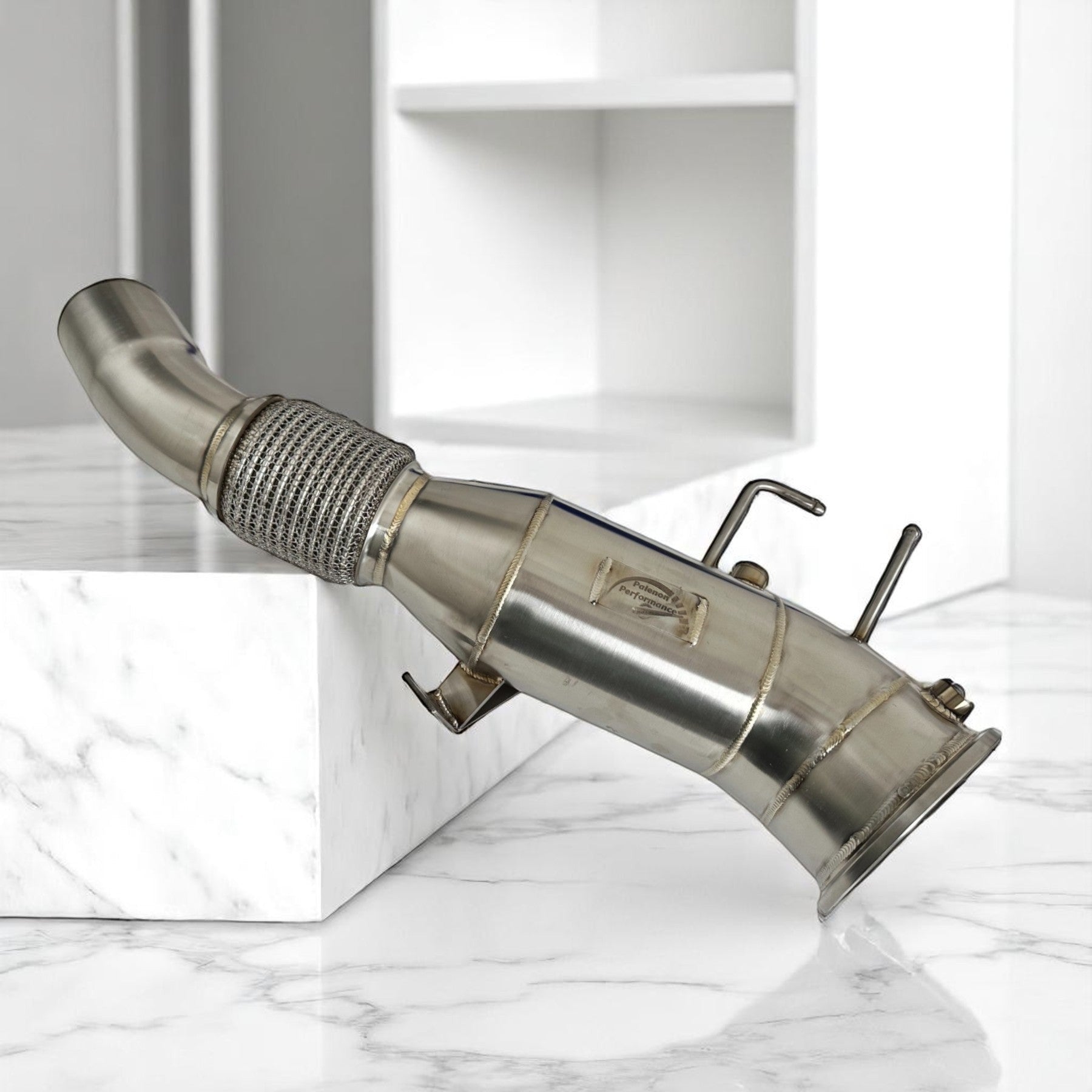 Palenon Performance 5-inch stainless steel racing downpipe for Gen 3 BMW B58TU2 engines on a marble display.