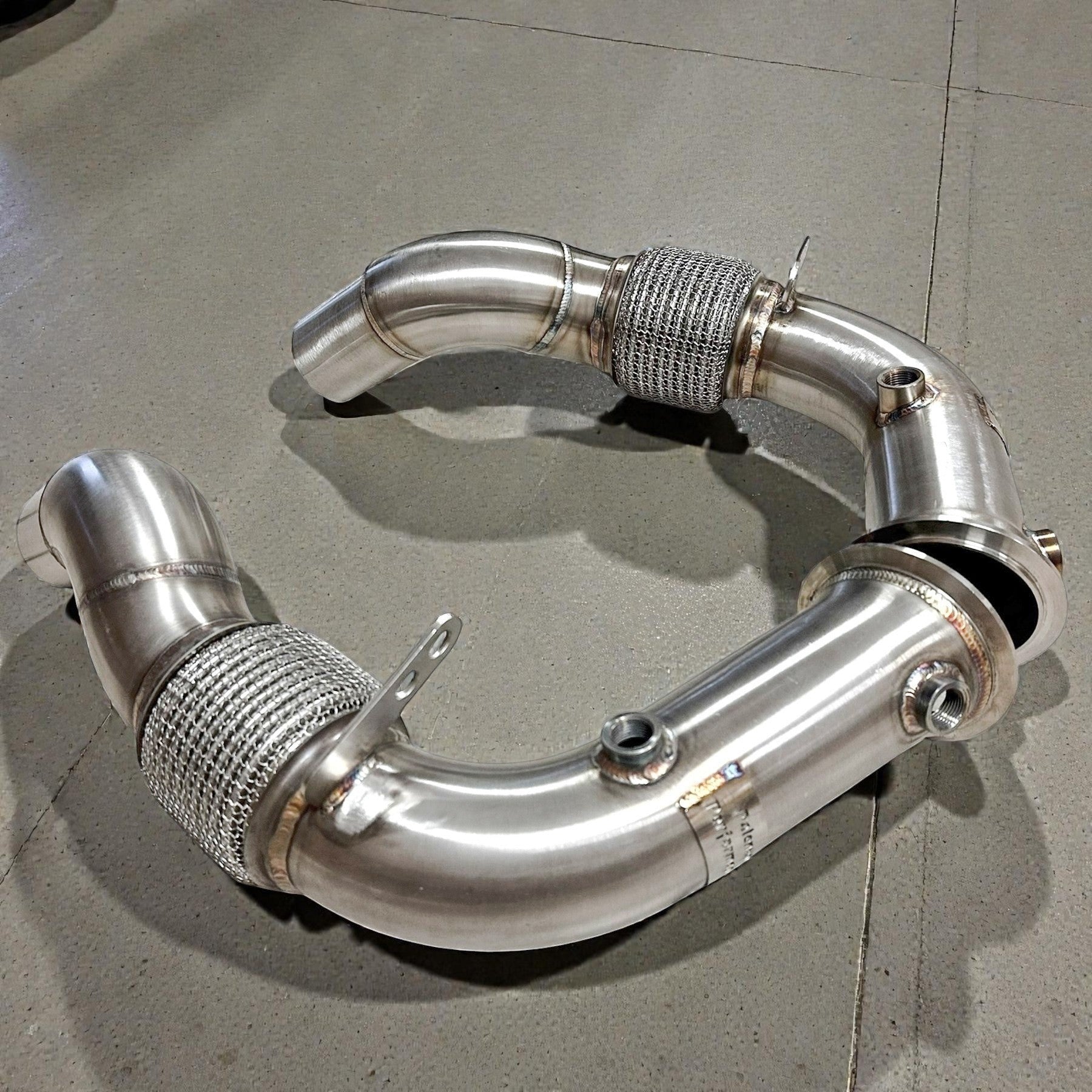 Palenon Performance stainless steel race downpipes for BMW S63 engines featuring flexible mesh sections and O2 bungs.