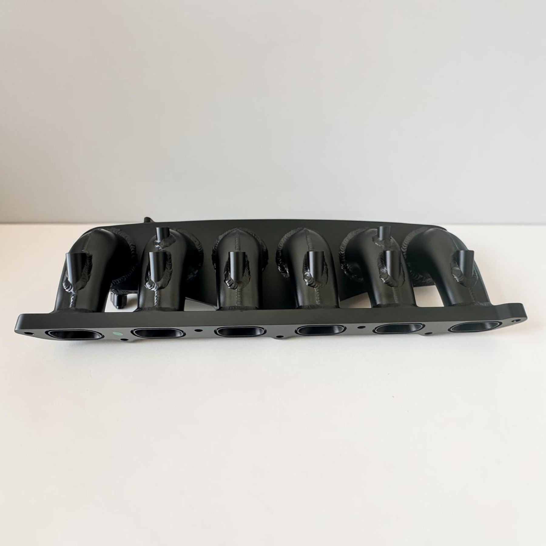 Palenon Performance aluminum intake manifold for BMW N54 engines with port injection bungs in a black finish.