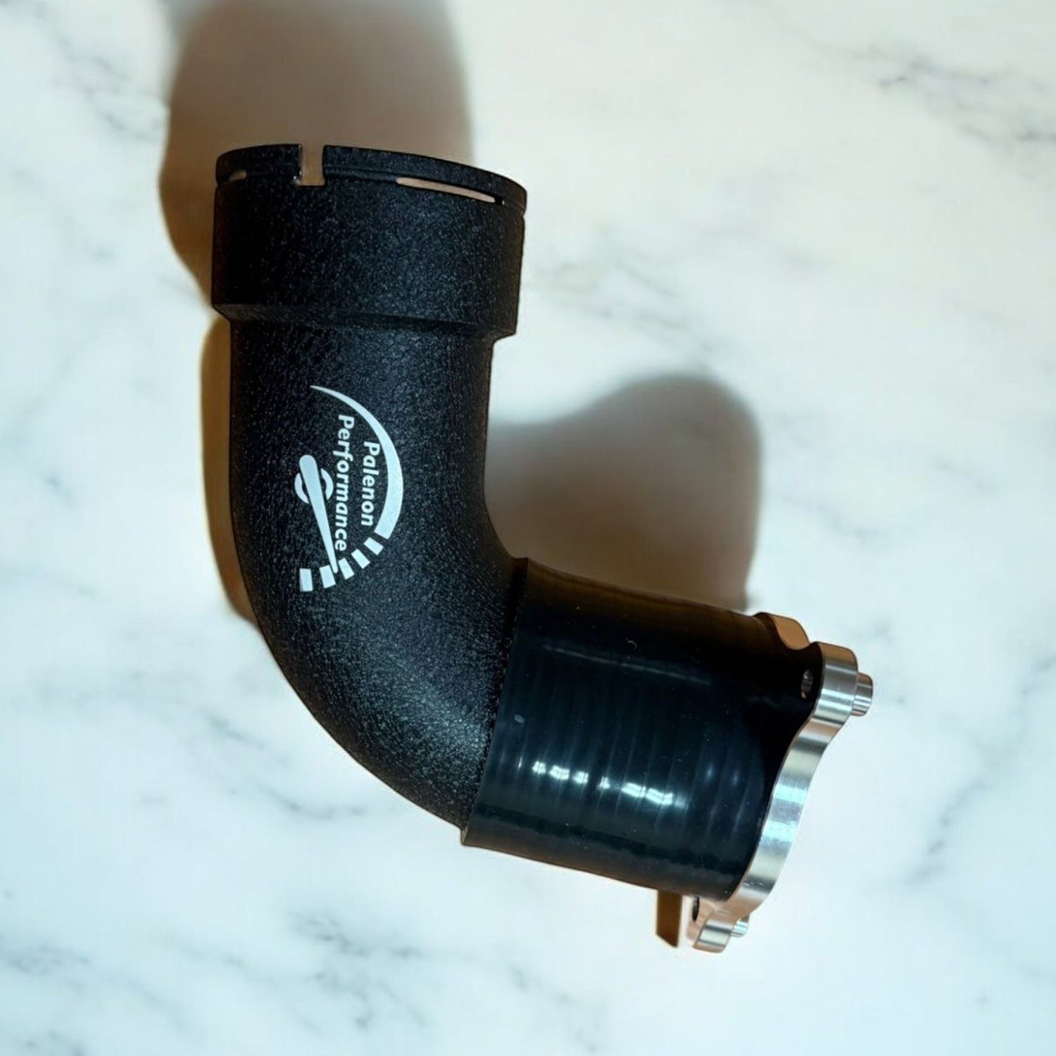 Palenon Performance matte black aluminum charge pipe for BMW S58 engines with CNC-machined flange and logo detail.