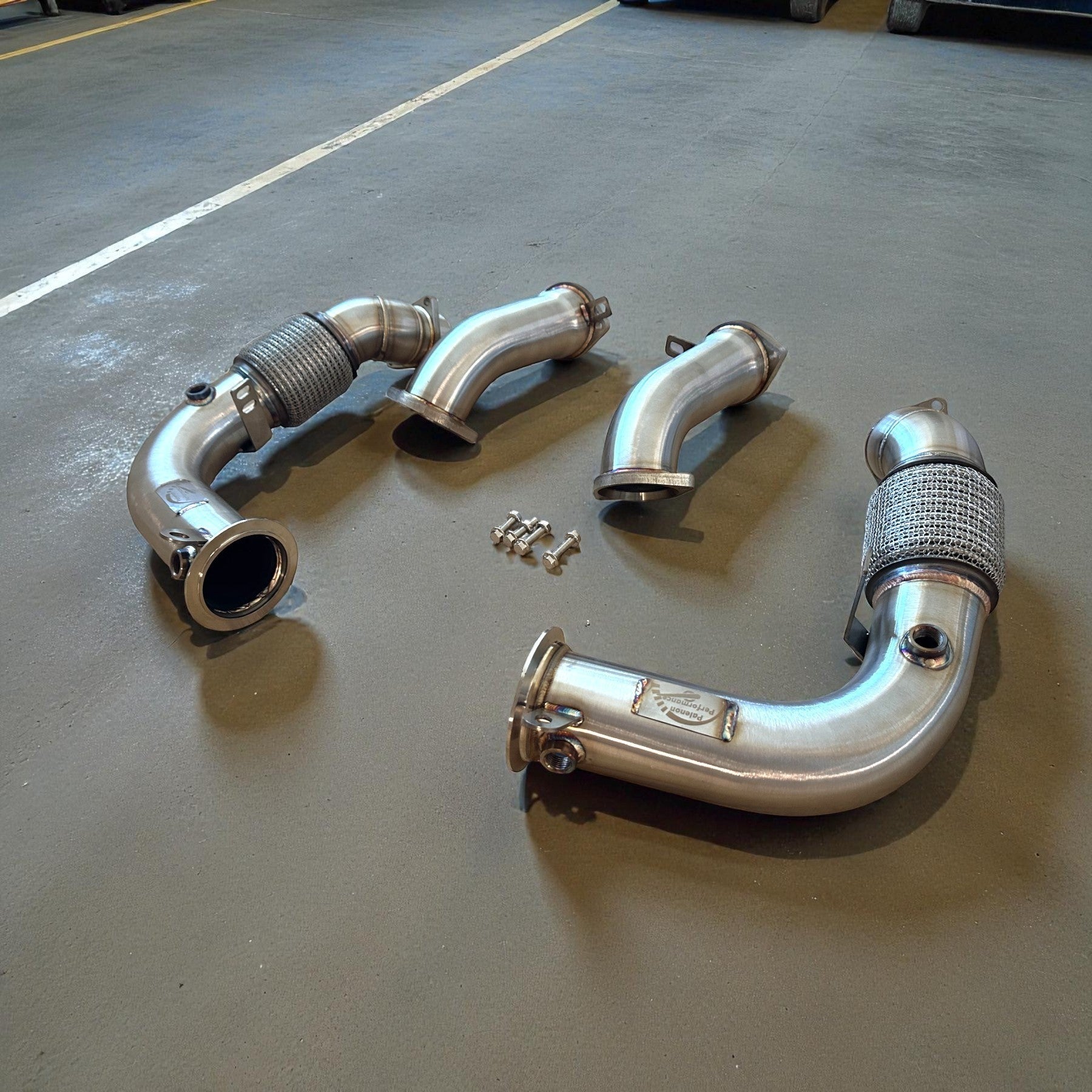 Palenon Performance stainless steel racing downpipes for BMW G90 and G99 M5 with precision flanges and hardware.