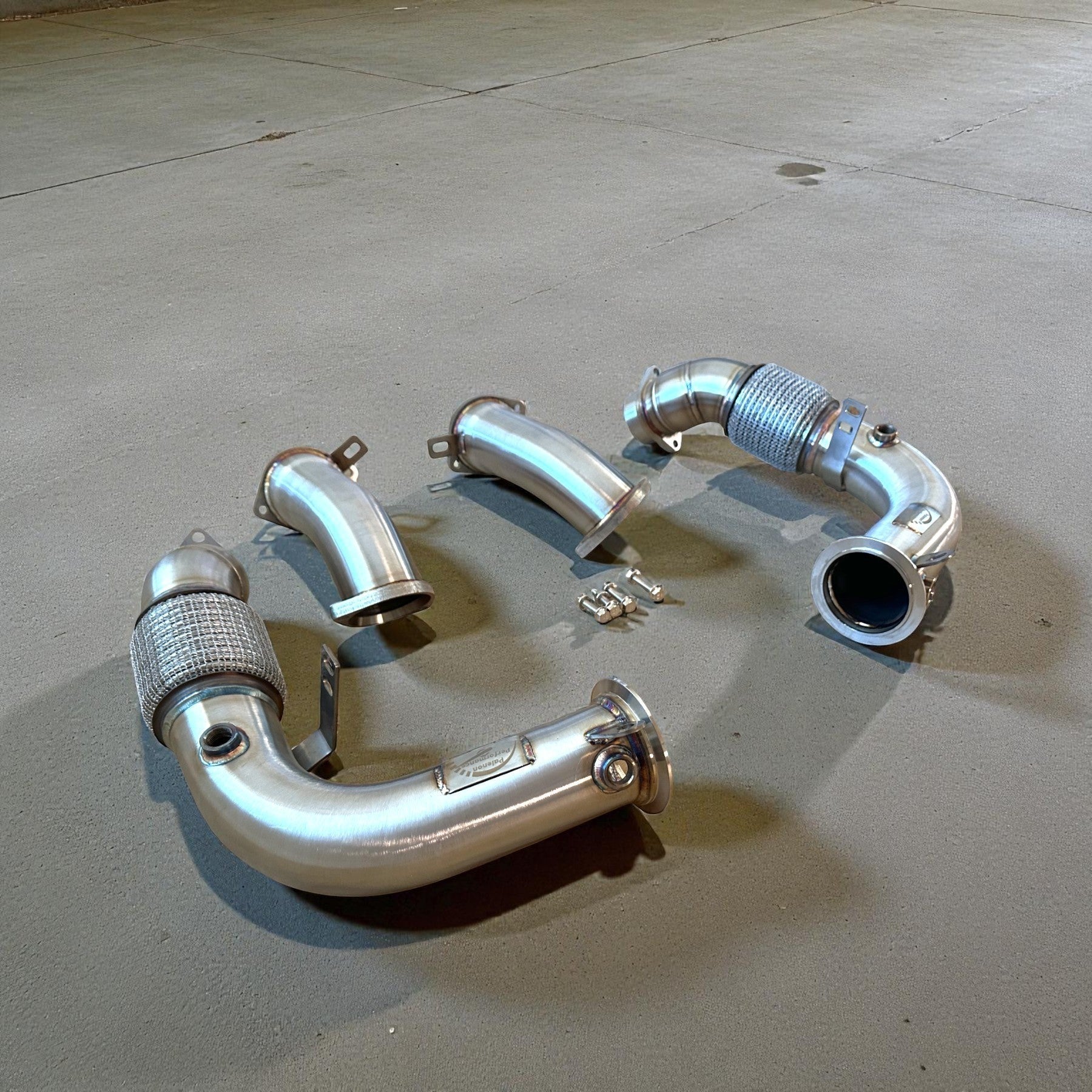 Palenon Performance stainless steel racing downpipes for BMW G90 and G99 M5, featuring precision flanges and TIG welds.