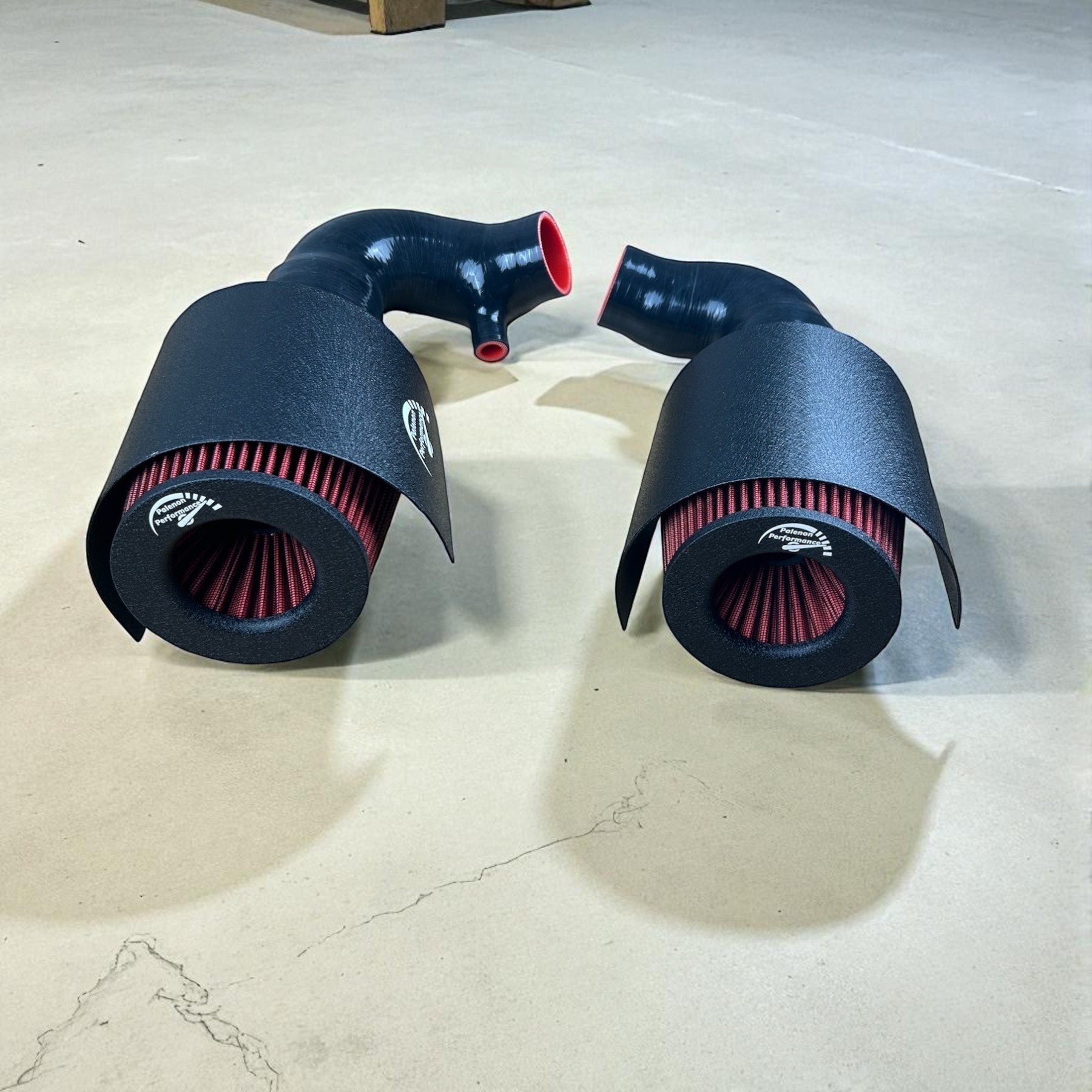 Palenon Performance cold air intake system with black heat shields, red high-flow filters, and black silicone piping.