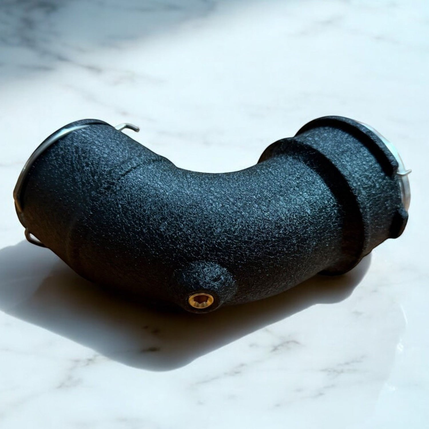 Palenon Performance matte black aluminum charge pipe for BMW S58 engines with NPT fitting on a marble surface.